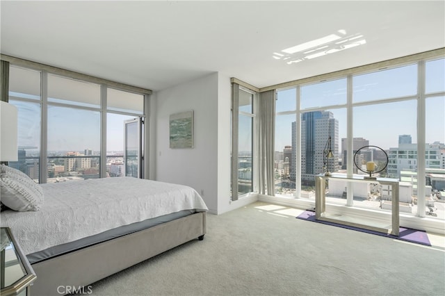 carpeted bedroom featuring multiple windows and floor to ceiling windows