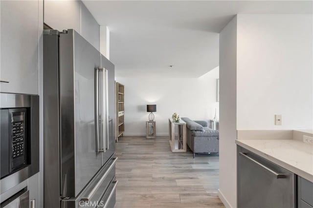 400 W Ocean Blvd Unit 1601, Long Beach, CA 90802 - kitchen with appliances with stainless steel finishes, light wood-type flooring, light stone countertops, open floor plan, and gray cabinetry