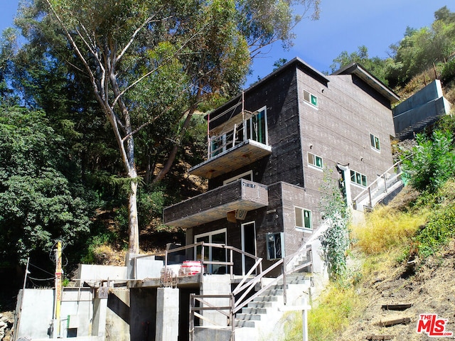 rear view of property featuring a balcony