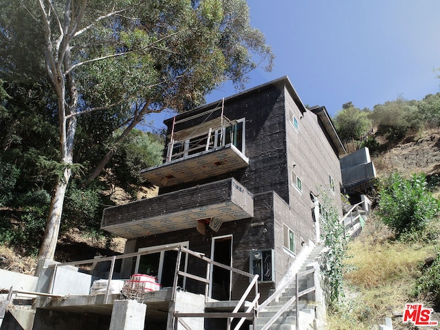 rear view of property featuring a balcony