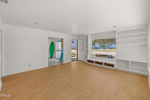 unfurnished living room with light hardwood / wood-style floors and a healthy amount of sunlight