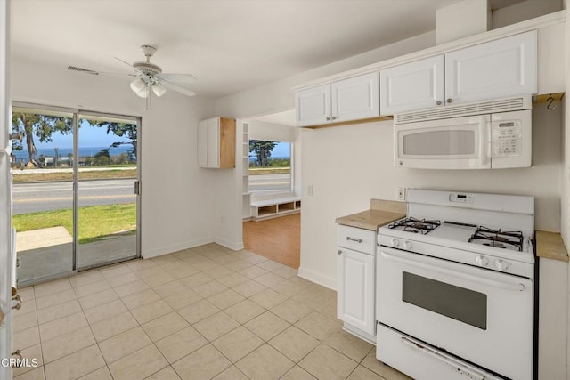 kitchen with white appliances, plenty of natural light, and white cabinets