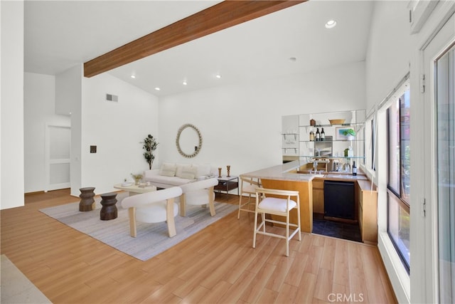 living room with beam ceiling, high vaulted ceiling, and light hardwood / wood-style floors