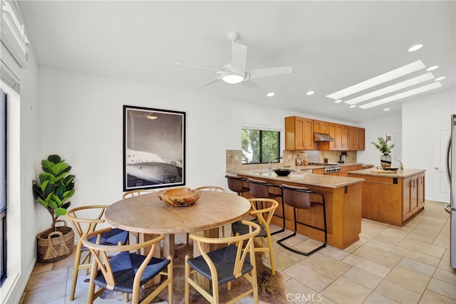 tiled dining room with a skylight and ceiling fan