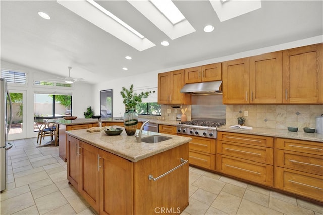32701 Via Palacio, Rancho Palos Verdes, CA 90275 - kitchen with appliances with stainless steel finishes, under cabinet range hood, a skylight, an island with sink, and backsplash