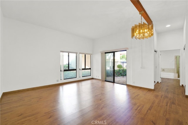 unfurnished room featuring a chandelier and hardwood / wood-style flooring