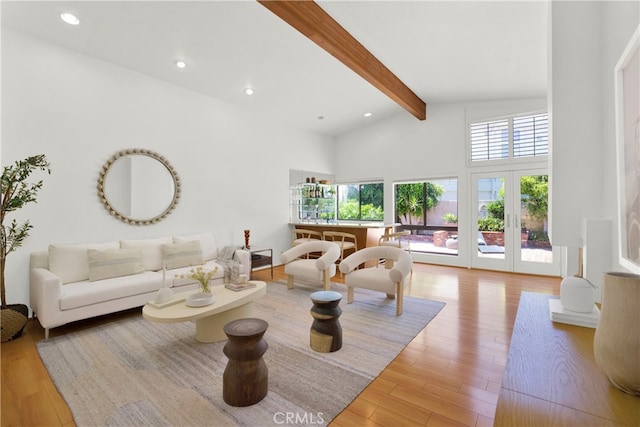 living room with beam ceiling, light wood-type flooring, high vaulted ceiling, and french doors