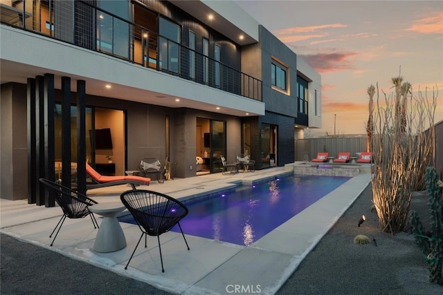 pool at dusk with a patio