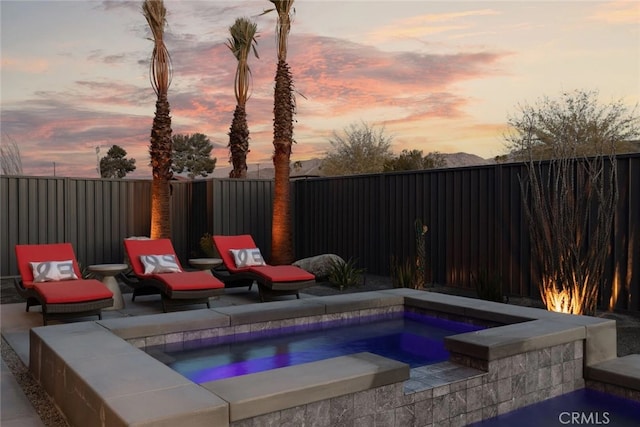 pool at dusk with a jacuzzi