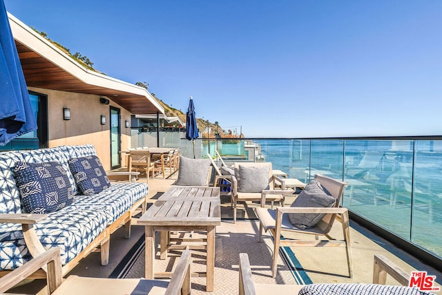 view of patio with a balcony and a water view