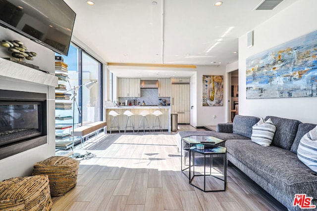 living room with floor to ceiling windows and light wood-type flooring