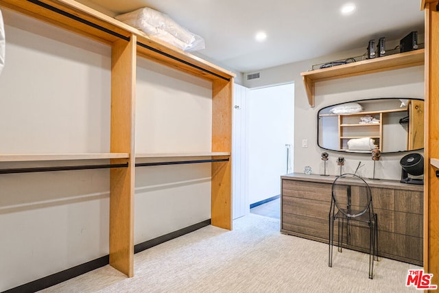 walk in closet featuring light colored carpet