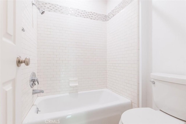 bathroom featuring toilet and tiled shower / bath