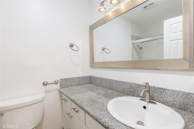 bathroom featuring vanity, toilet, and a shower with shower door