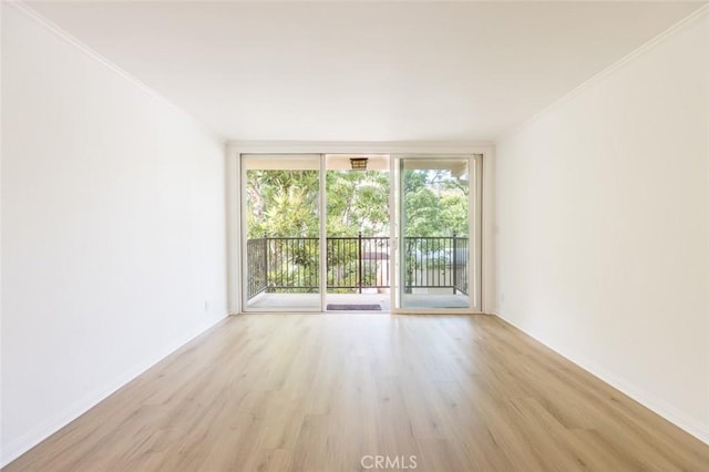 unfurnished room featuring floor to ceiling windows, light wood-type flooring, and crown molding