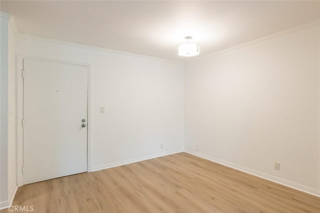 empty room featuring light hardwood / wood-style floors and ornamental molding