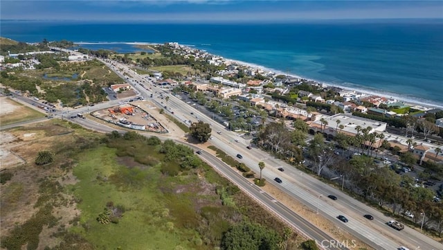 drone / aerial view featuring a water view and a view of the beach