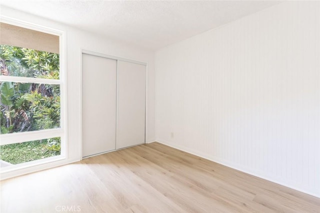 unfurnished bedroom featuring light hardwood / wood-style flooring and a closet