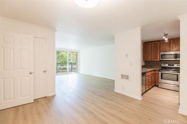 kitchen with floor to ceiling windows, decorative backsplash, light hardwood / wood-style flooring, and stainless steel appliances