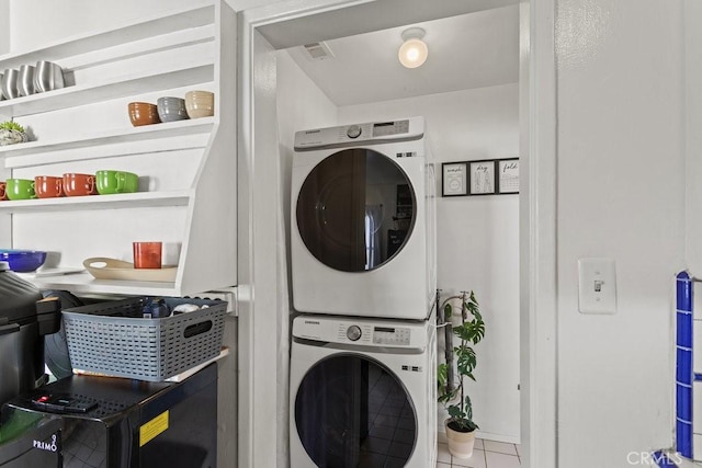 laundry area featuring tile patterned flooring and stacked washer and dryer