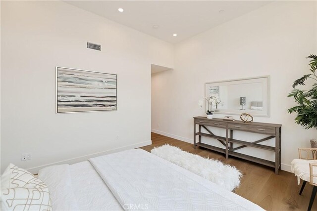 bedroom with a towering ceiling and dark hardwood / wood-style floors