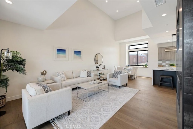 living room featuring light hardwood / wood-style floors and a high ceiling