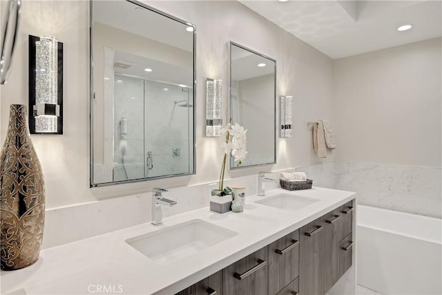 bathroom featuring shower with separate bathtub and vanity