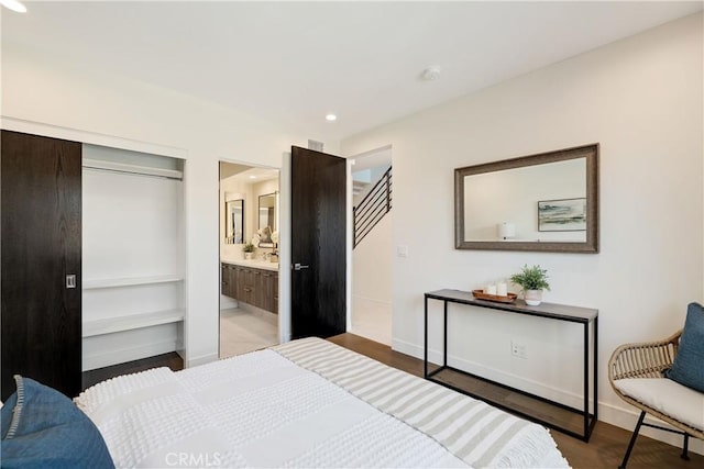 bedroom featuring connected bathroom and light hardwood / wood-style flooring