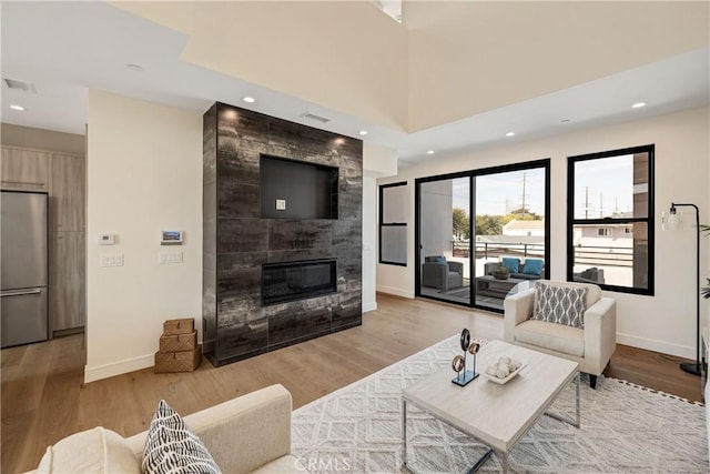 living room with light wood-type flooring and a fireplace