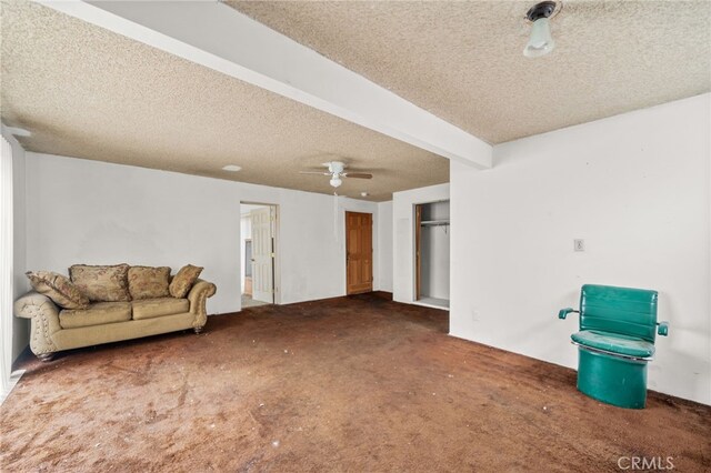 carpeted living room with beam ceiling, ceiling fan, and a textured ceiling