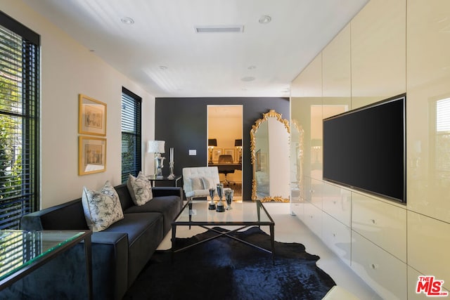 living room featuring a wealth of natural light and concrete floors