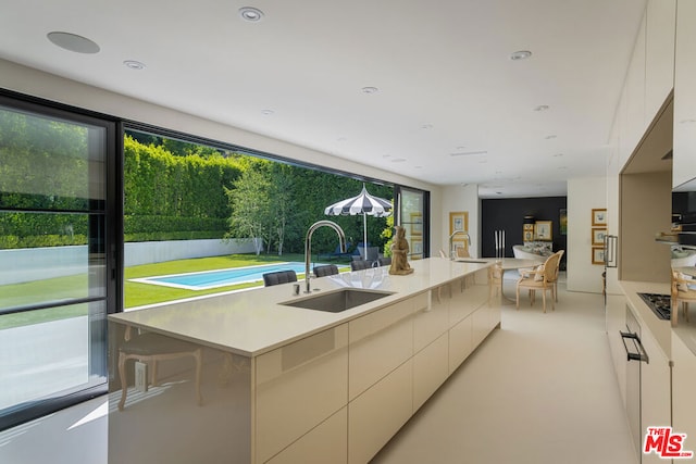 kitchen with a breakfast bar, a center island, sink, and a wealth of natural light