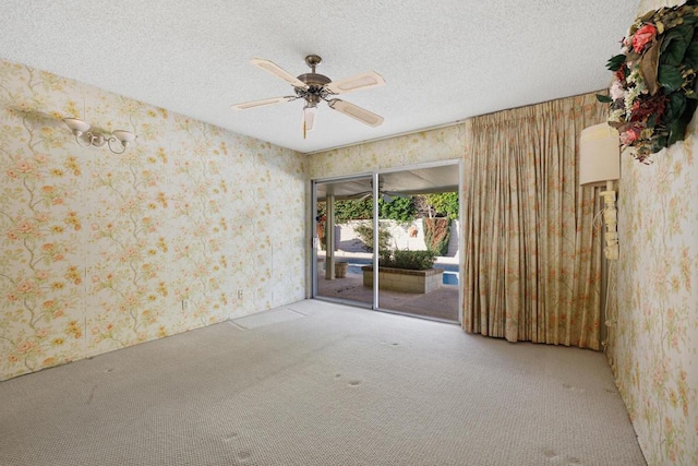 carpeted spare room featuring a textured ceiling and ceiling fan