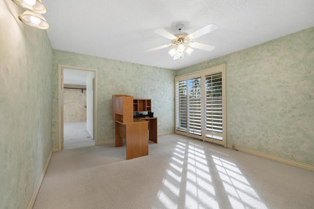 unfurnished office featuring ceiling fan and light colored carpet