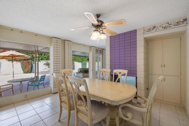 dining area featuring ceiling fan, a textured ceiling, and light tile patterned floors