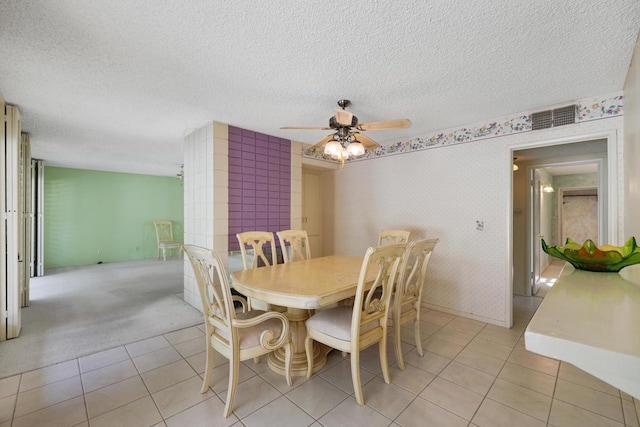 tiled dining area with a textured ceiling and ceiling fan