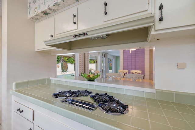 kitchen featuring white cabinets, tile countertops, and gas stovetop