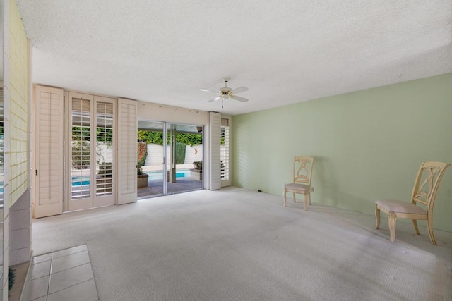 carpeted empty room with ceiling fan and a textured ceiling