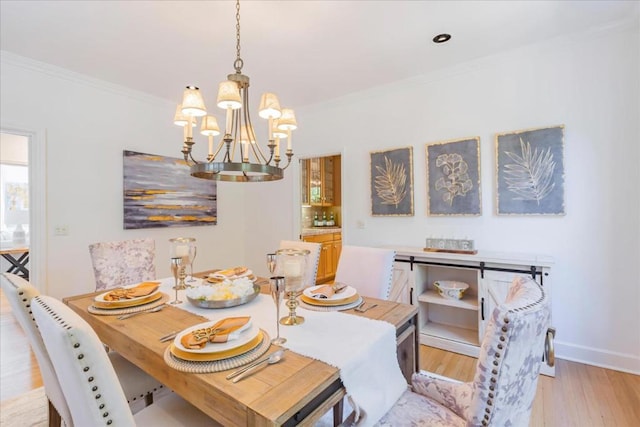 dining area featuring a notable chandelier, crown molding, and light wood-type flooring