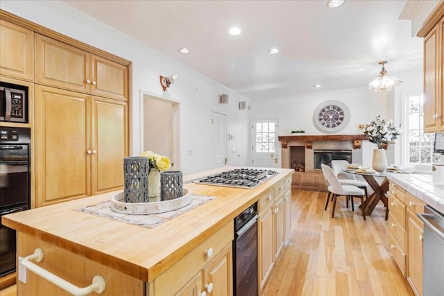 kitchen featuring crown molding, wooden counters, light wood-type flooring, a kitchen island, and stainless steel appliances