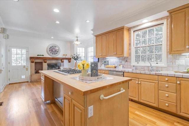 kitchen featuring tasteful backsplash, a kitchen island, sink, and wood counters