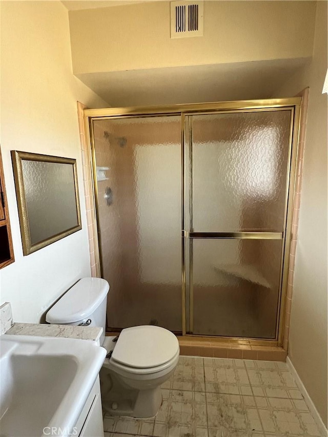 bathroom featuring toilet, a shower with door, and vanity