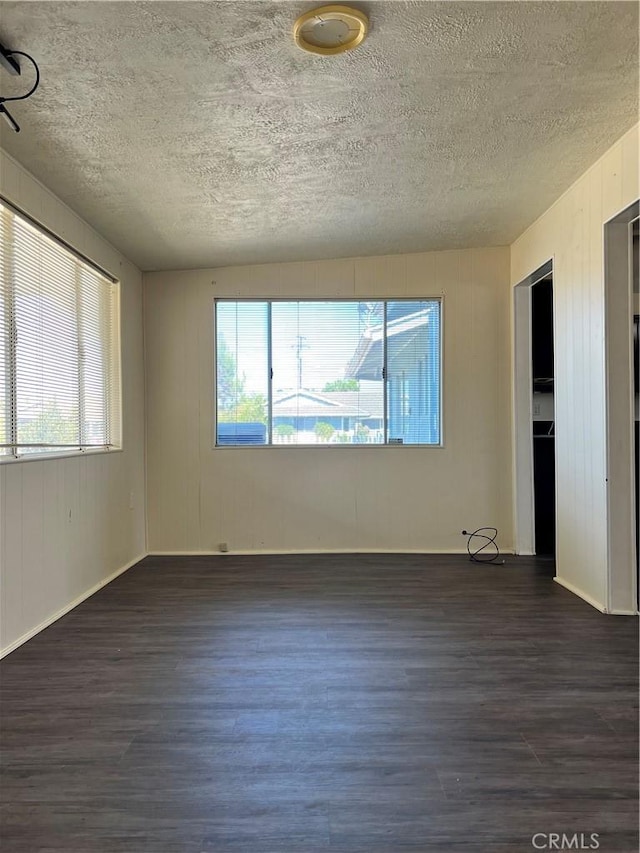 empty room featuring dark hardwood / wood-style flooring and a textured ceiling