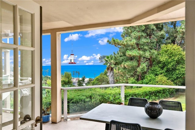 sunroom / solarium featuring a water view