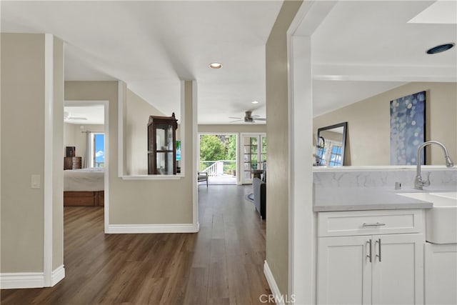 hallway with baseboards, dark wood-style flooring, a sink, and recessed lighting