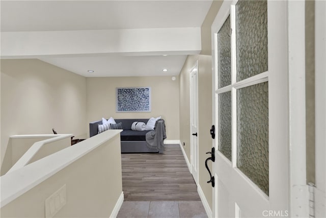 hall with recessed lighting, an upstairs landing, and baseboards