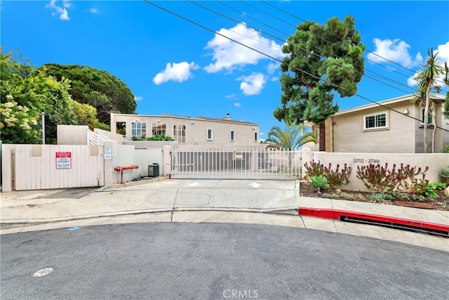 view of front of property featuring a fenced front yard, a gate, and stucco siding