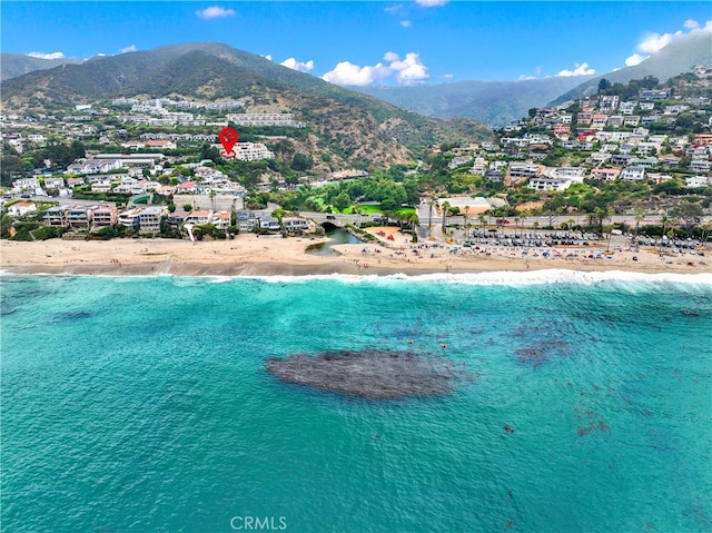 birds eye view of property featuring a view of the beach and a water and mountain view