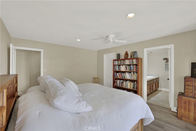 bedroom with light wood finished floors, a ceiling fan, connected bathroom, and recessed lighting