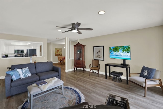 living room with a ceiling fan, recessed lighting, baseboards, and wood finished floors